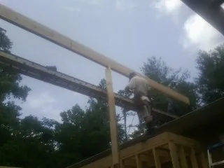 Carpenter setting a ridge beam over a new addition frame — Ice Dam Removal by Roofing Brothers in Tappan