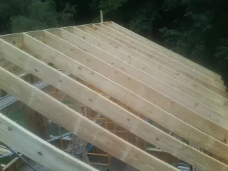 New roof rafters set over an addition before sheathing in Tappan