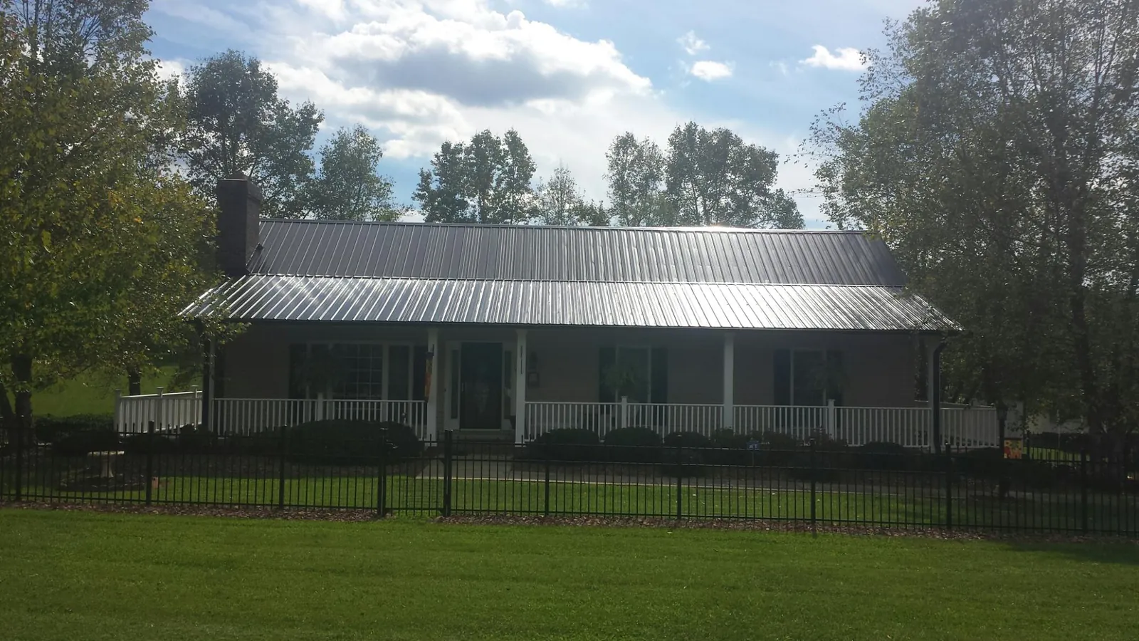 Gray metal roof on a brick ranch with a full width front porch — Gutter Guard Installation work by our crew in Tappan