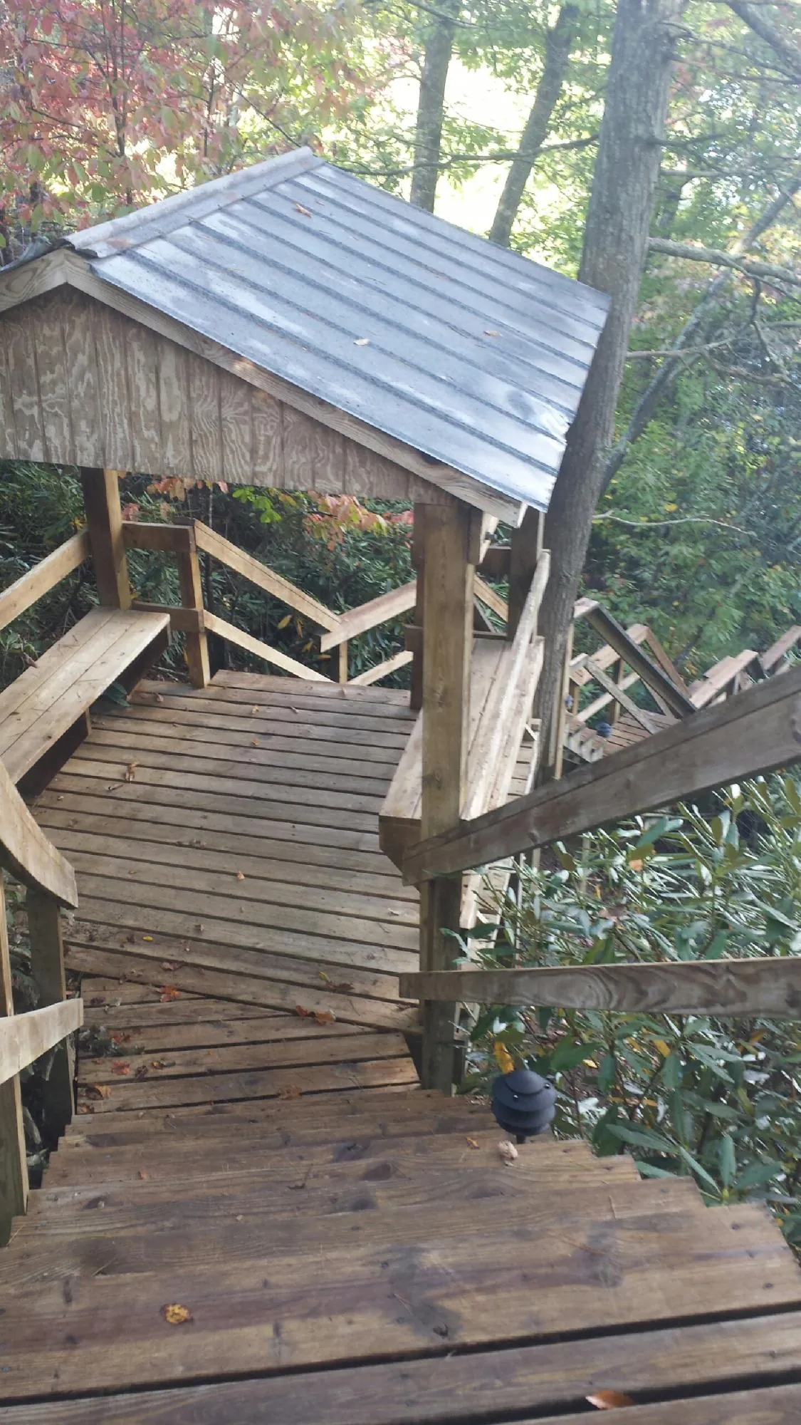 Metal roofed shelter over wooden steps on a wooded walkway — Skylight Repair & Installation work by our crew in Tappan
